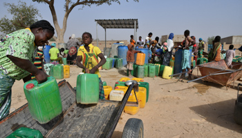 Displaced people carry their jerrycans at a water point near the UNHCR camp in Pissila, Burkina Faso, January 24 (Reuters/Anne Mimault)