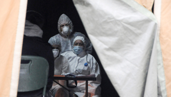 Medical staff in protective suits inside a tent for those suspected of being infected with COVID-19, Prishtina, March 25 (Reuters/Laura Hasani)