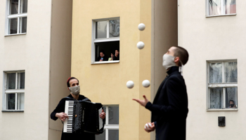 Masked street entertainers perform for Prague residents under lockdown, April 14 (Reuters/David W Cerny)