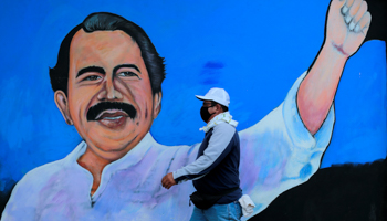 A man, wearing a face mask for protection against COVID-19, walks by a mural depicting President Daniel Ortega, in Managua, March 30 (Reuters/Oswaldo Rivas)
