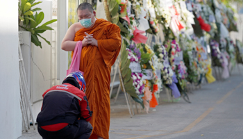 A monk receives alms at a temple in Bangkok, Thailand, April 21 (Reuters/Jorge Silva)