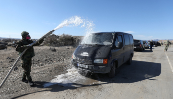 A Georgian serviceman washes down a van at a checkpoint (Reuters/Irakli Gedenidze)