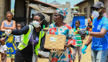 Volunteers direct an elderly woman at an ongoing distribution of food parcels, during a COVID-19-related lockdown, Lagos, April 9 (Reuters/Temilade Ade)