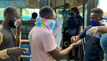 Public transport staff offers hand sanitiser to passengers on the first day of the easing of the lockdown measures in Lagos, May 4 (Reuters/Temilade Adelaja)