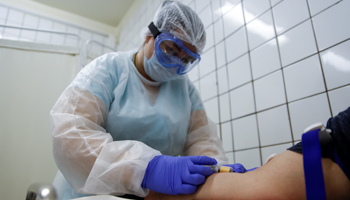 A healthcare worker takes blood samples from a person during COVID-19 testing at a Moscow clinic (Reuters/Maxim Shemetov)