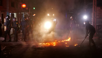 Riot police try to put out fire during protests over a nationwide dusk-to-dawn curfew imposed because of COVID-19, Dakar, Senegal, June 4 (Reuters/Christophe Van Der Perre)