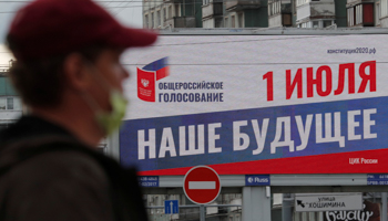 A man wearing a facemask walks past a billboard in St. Petersburg advertising the July 1 vote on constitutional changes (Reuters/Anton Vaganov)