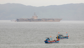 The USS Theodore Roosevelt seen near Vietnamese fishing boats in March (Reuters/Kham)
