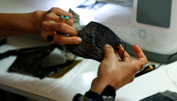Salam Dajani, a Jordanian designer, sews eggplant skin to make sustainable face masks, June 8 (Reuters/Muhammad Hamed)