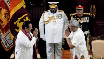 Prime Minister Mahinda Rajapaksa (left) and his brother, President Gotabaya Rajapaksa (right), gesturing at Mahinda’s swearing-in ceremony last November (Reuters/Dinuka Liyanawatte)