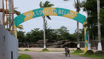 A man rides a bicycle under a sign welcoming visitors to Belize, Belize City (Reuters/Henry Romero)