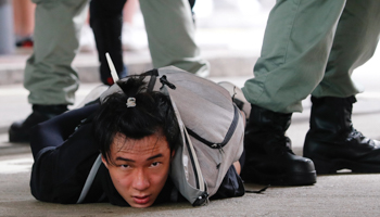 A man is detained by Hong Kong riot police during a march against the national security law (Reuters/Tyrone Siu)