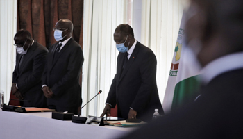 Ivory Coast’s President Alassane Ouattara (C) and government members stand for a minute silence in respect for the late Prime Minister Amadou Gon Coulibaly before a cabinet meeting in Abidjan, July 13 (Reuters/Thierry Gouegnon)