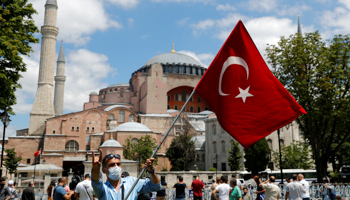 A man waves the Turkish flag and gives the Grey Wolf nationalist gesture outside Hagia Sophia, Istanbul, July 17 (Reuters/Murad Sezer)