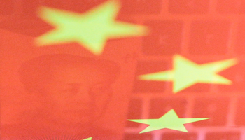 A banknote and computer keyboard reflected on an image of the Chinese flag (Reuters/Florence Lo/Illustration)