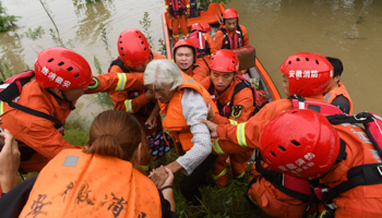 Rescue workers evacuate flood-affected residents, July 21 (Reuters)