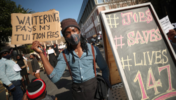 A restaurant worker holds a placard during a protest against COVID-19 restrictions, Cape Town, July 22 (Reuters/Mike Hutchings)
