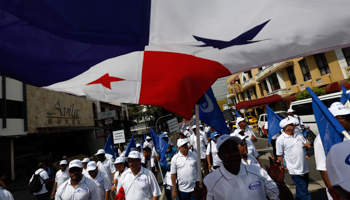 A Panamanian flag is seen above a union labour group during a May Day/Labour Day demonstration in Panama City in 2014 (Reuters/Carlos Jasso)