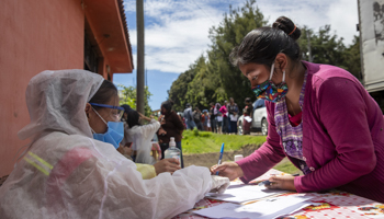 Woman receiving COVID-19-related aid in San Jose Calderas, Guatemala (Moises Castillo/AP/Shutterstock)