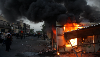 Shia militia supporters burn a local TV channel building in Baghdad (Khalid Mohammed/AP/Shutterstock)