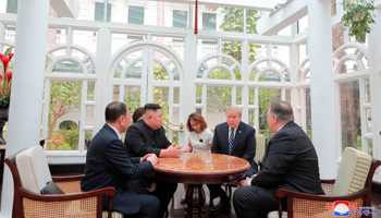 US President Donald Trump and North Korean leader Kim Jong Un, with aides and other officials during their 2019 summit in Vietnam (Uncredited/AP/Shutterstock)