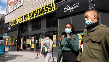 People wearing masks walk by Century 21 department store, in Brooklyn, New York (Mark Lennihan/AP/Shutterstock)