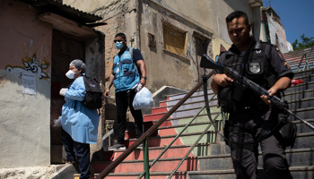 Police patrol in Rio de Janeiro as health workers administer COVID-19 tests (Silvia Izquierdo/AP/Shutterstock)