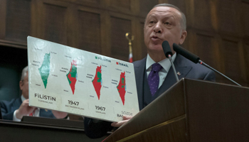 Turkish President Recep Tayyip Erdogan holds up a board denouncing Israel’s seizure of territory from the Palestinians (Burhan Ozbilici/AP/Shutterstock)