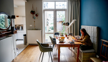 A woman works remotely amid pandemic lockdowns (Robin Utrecht/Shutterstock)
