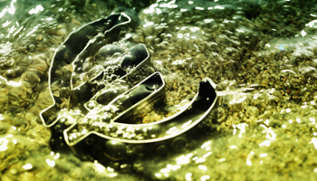 Euro symbol washed over with water, symbolic image for the euro crisis (Christian Ohde/imageBROKER/Shutterstock)