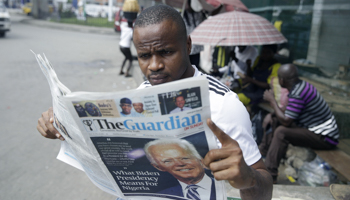 A man in Lagos, Nigeria, reads a newspaper reacting to the news of Joe Biden's victory in the US presidential election (Sunday Alamba/AP/Shutterstock)