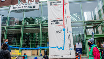 Extinction Rebellion activists hang a huge banner on the Ministry of Economic Affairs and Climate Policy building, in The Hague (Ana Fernandez/SOPA Images/Shutterstock)