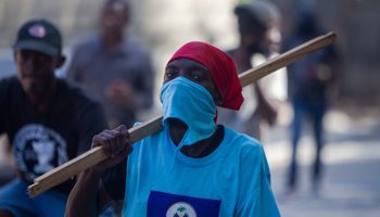 A man marches with a stick during a protest against President Jovenel Moise in Port-au-Prince, Haiti, January 2021 (JEAN MARC HERVE ABELARD/EPA-EFE/Shutterstock)