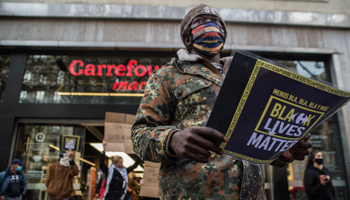 A protester with a Black Lives Matter sign outside a Carrefour outlet following the death of a Black man beaten by Carrefour security guards (Thiago Prudencio/SOPA Images/Shutterstock)