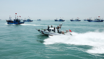 A China Coast Guard vessel patrols near fishing boats at sea (Xinhua/Shutterstock)