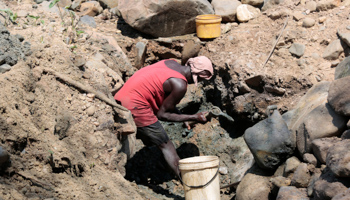 A man digs the ground in search of gold-rich soil for the process of gold panning along the Odzi River outside Mutare, November 7, 2020 (Aaron Ufumeli/EPA-EFE/Shutterstock)