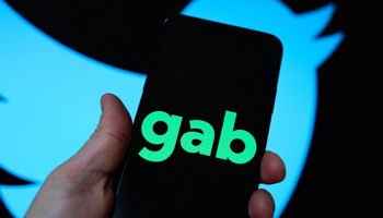 The Gab logo is seen on a mobile device with the Twitter logo in the background. Gab is an American alt-tech social network known for it's far-right userbase (Jaap Arriens/NurPhoto/Shutterstock)