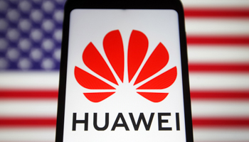 Huawei logo displayed on a mobile phone with the US flag in the background (Pavlo Gonchar/SOPA Images/Shutterstock)