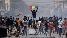 A demonstrator holds up a Senegalese flag during protests following the arrest of opposition leader and former presidential candidate Ousmane Sonko in Dakar, March 5 (Leo Correa/AP/Shutterstock)