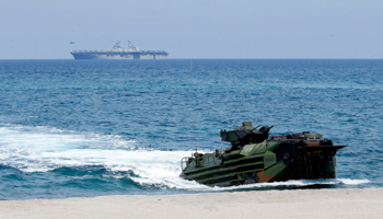 A US Navy amphibious assault ship (background) and amphibious assault vehicle (foreground) during a military exercise (Bullit Marquez/AP/Shutterstock)