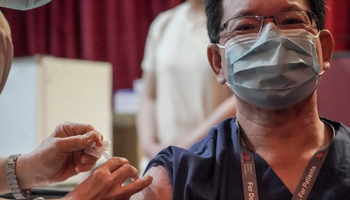 A healthcare worker receiving a COVID-19 vaccine dose in Singapore (Wallace Woon/EPA-EFE/Shutterstock)