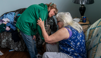 A Quick Response Team member comforts a woman in Huntington, West Virginia, whose struggles with addiction have been made worse by the pandemic, March 17 (David Goldman/AP/Shutterstock)