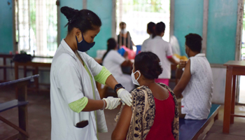 A woman receiving a COVID-19 vaccine dose (Anuwar Hazarika/NurPhoto/Shutterstock)