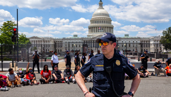 A Capitol Police officer stands in front of peaceful protesters who are blocking the street in front of the Capitol as part of a civil disobediance action to protest against the filibuster, Washington DC, June 24, 2021 (Allison Bailey/Shutterstock)