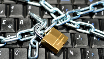Keyboard of a computer protected by a chain and a lock (Frederic Sierakowski/Shutterstock)