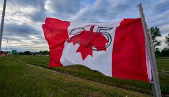 A Canadian flag hung upside down in protest at the deaths of 215 children found in an unmarked mass grave at a former Indian Residential School, July 2 (Andre Pichette/EPA-EFE/Shutterstock)