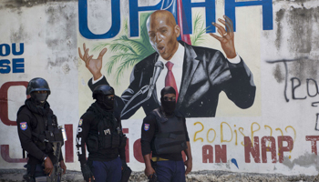 Police stand by a mural of Moise, near the house where he was assassinated. Port-au-Prince, July 7 (Joseph Odelyn/AP/Shutterstock)