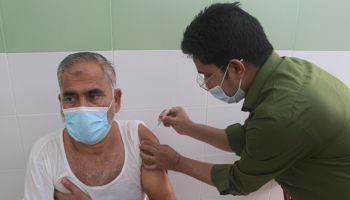 A man receiving a COVID-19 vaccine dose in Bangladesh (Md Rafayat Haque Khan/ZUMA Wire/Shutterstock)