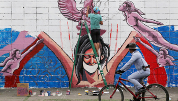 An artist in the Philippines painting a mural about prostitution and human trafficking (AP/Shutterstock)