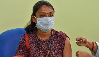 A woman receiving a COVID-19 vaccine dose in Kolkata (Majority World/Shutterstock)